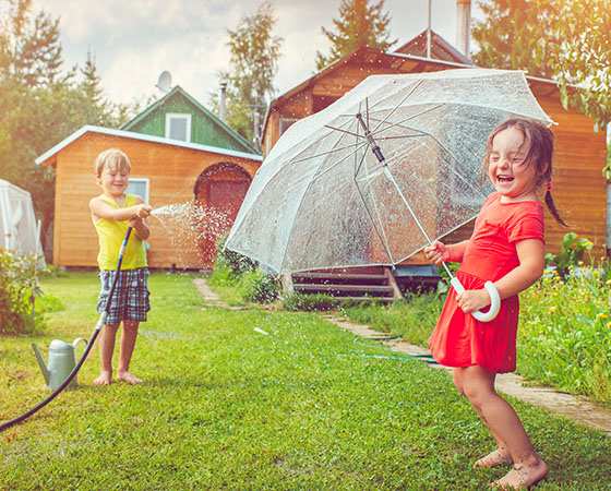 boy and girl playing in sprinkler