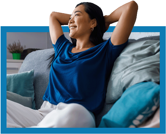 Asian woman sitting on couch smiling