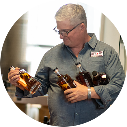 man looking at bottles coming off production line