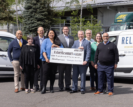 Washington Trust Bank employees present a check to an organization.