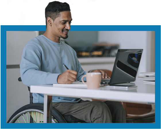 Hispanic man in a wheelchair working on a computer