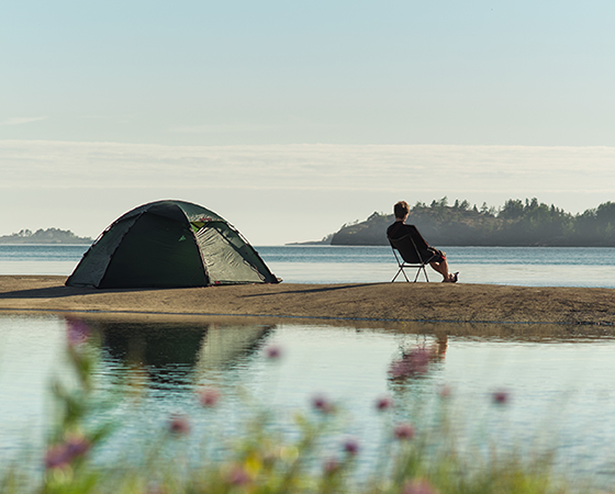 man with tent on river