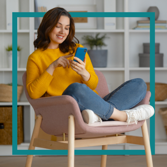 Woman holding a smartphone sitting in a chair