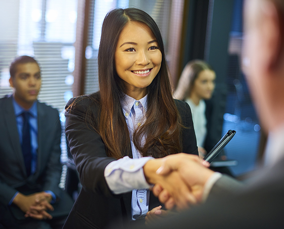 Asian woman shaking hands with businessman