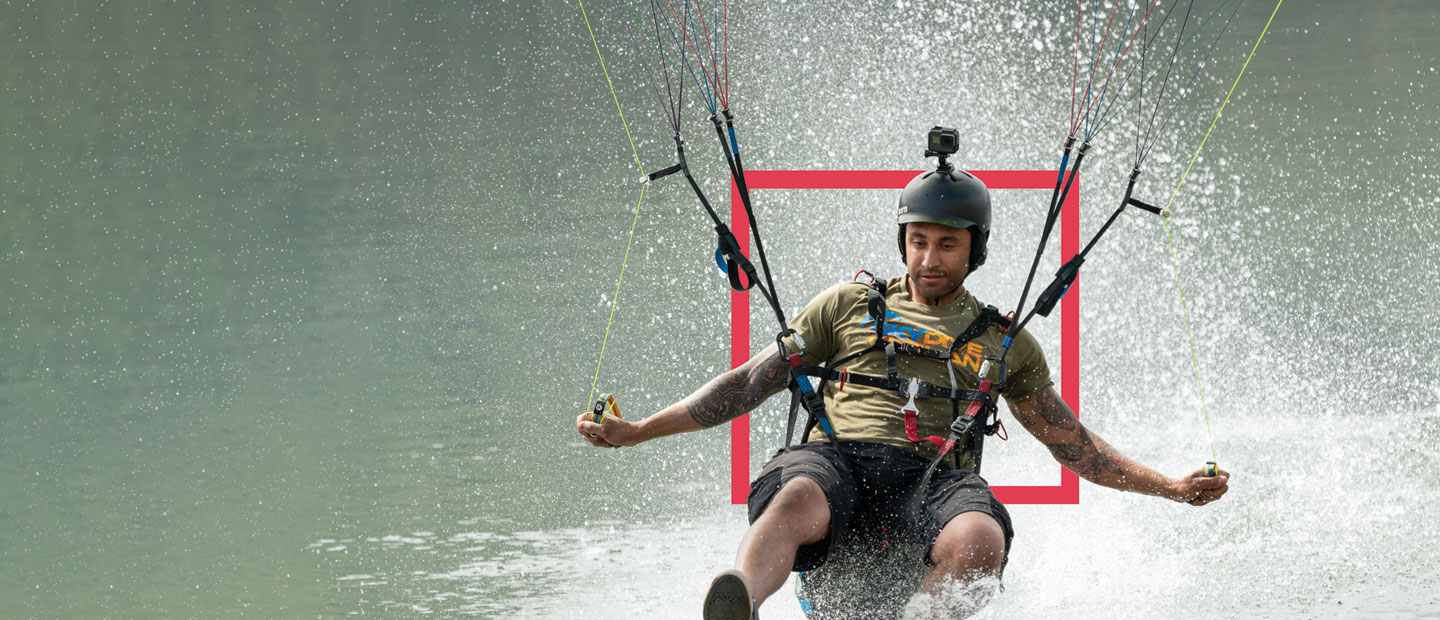 man in parasail landing on water