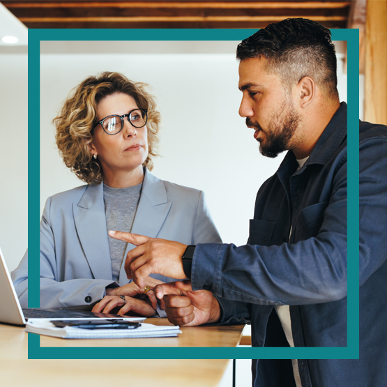 Hispanic business man and woman having discussion over laptop